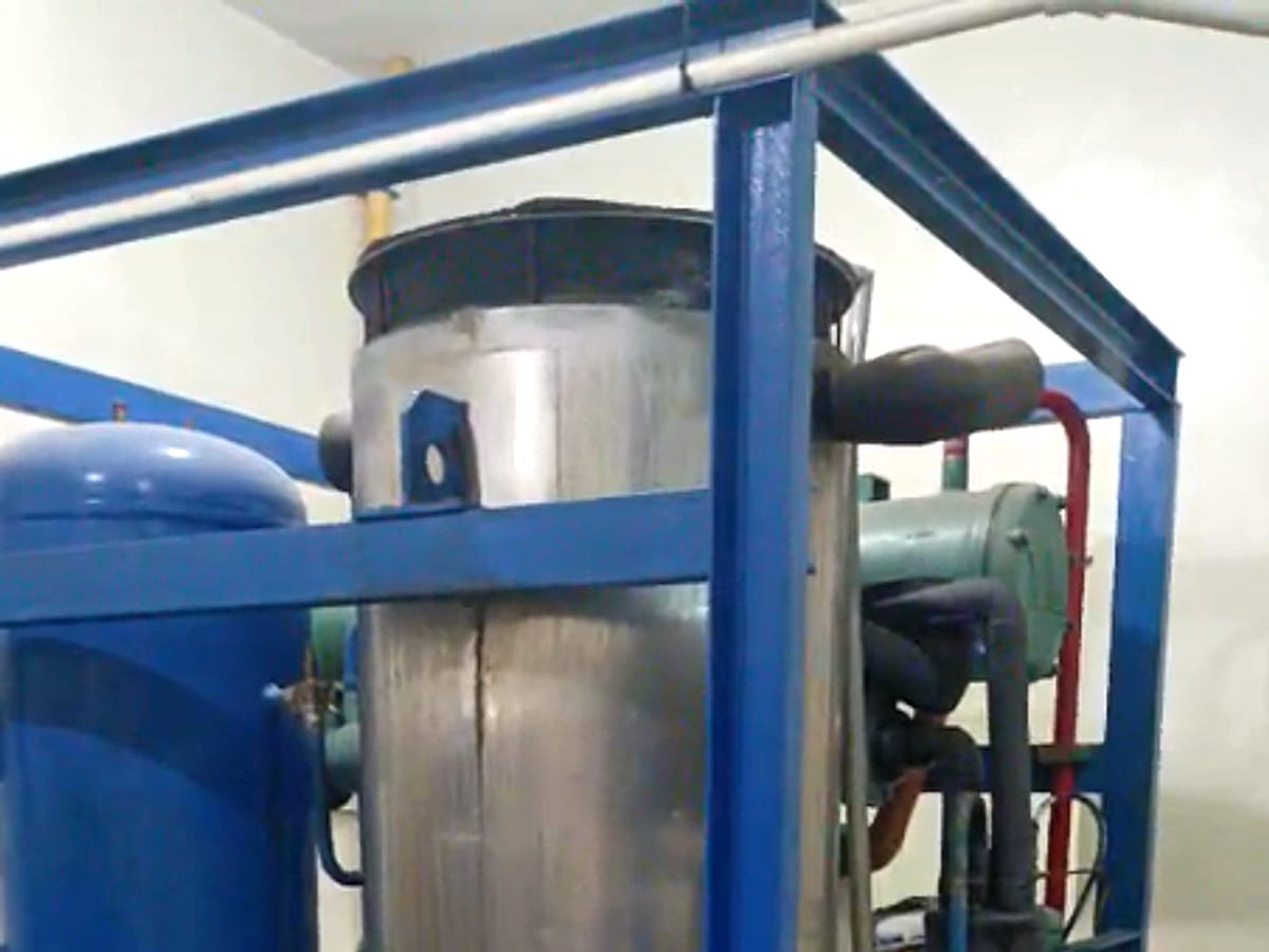 Stainless steel industrial tube ice machine mounted on a blue steel frame